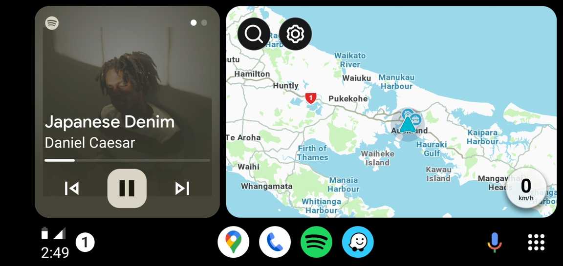 Screenshot of Android Auto showing a split layout. The left-side of the split shows Spotify, and the right-side shows Waze.